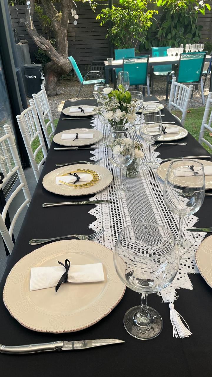 Mesa elegante montada con mantelería negra en evento real